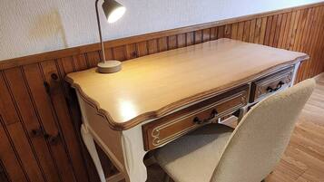 Ein Holztisch mit einer Lampe, einem Stuhl und Holzboden.