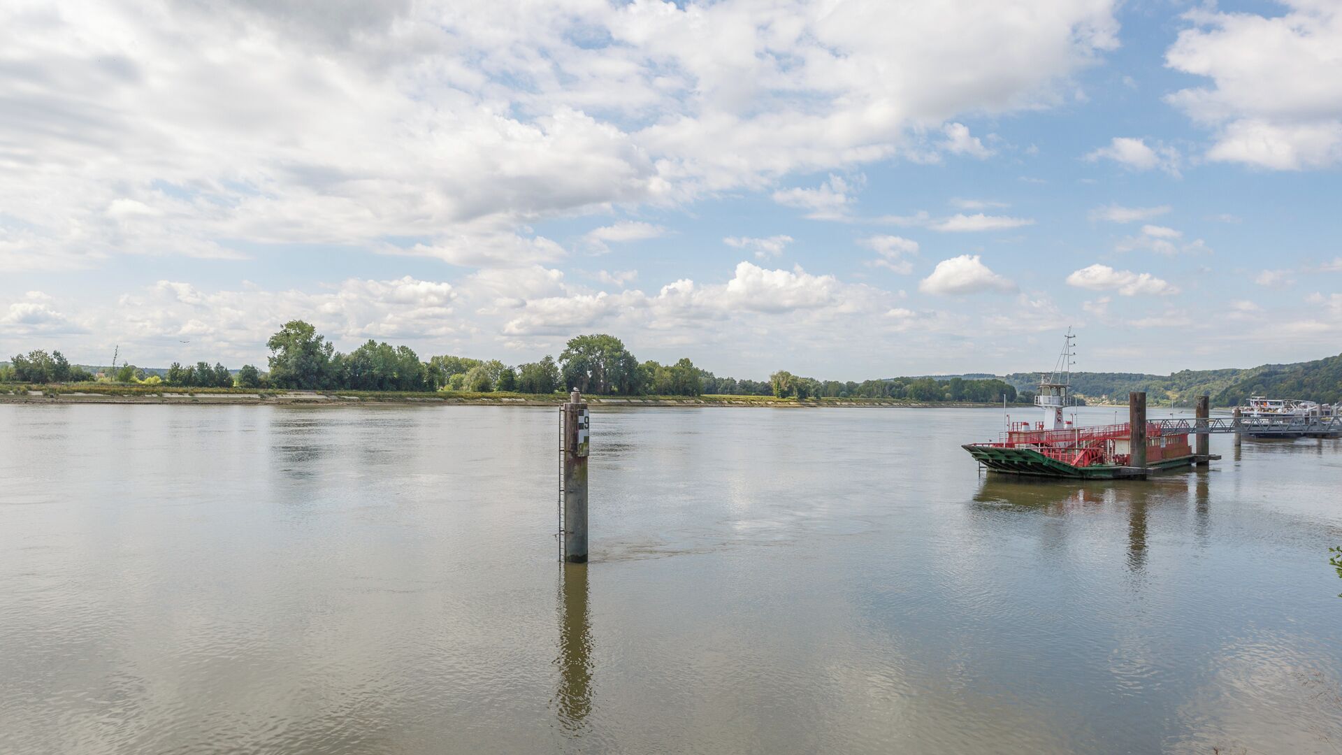 A calm river with a boat docked on the right.