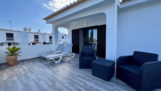 A rooftop terrace with a tiled floor, white walls, and a tiled roof. There are two lounge chairs and two dark wicker sofas. - ALBUFEIRA SUMMER VILLA 3 WITH POOL by HOMING (Albufeira)