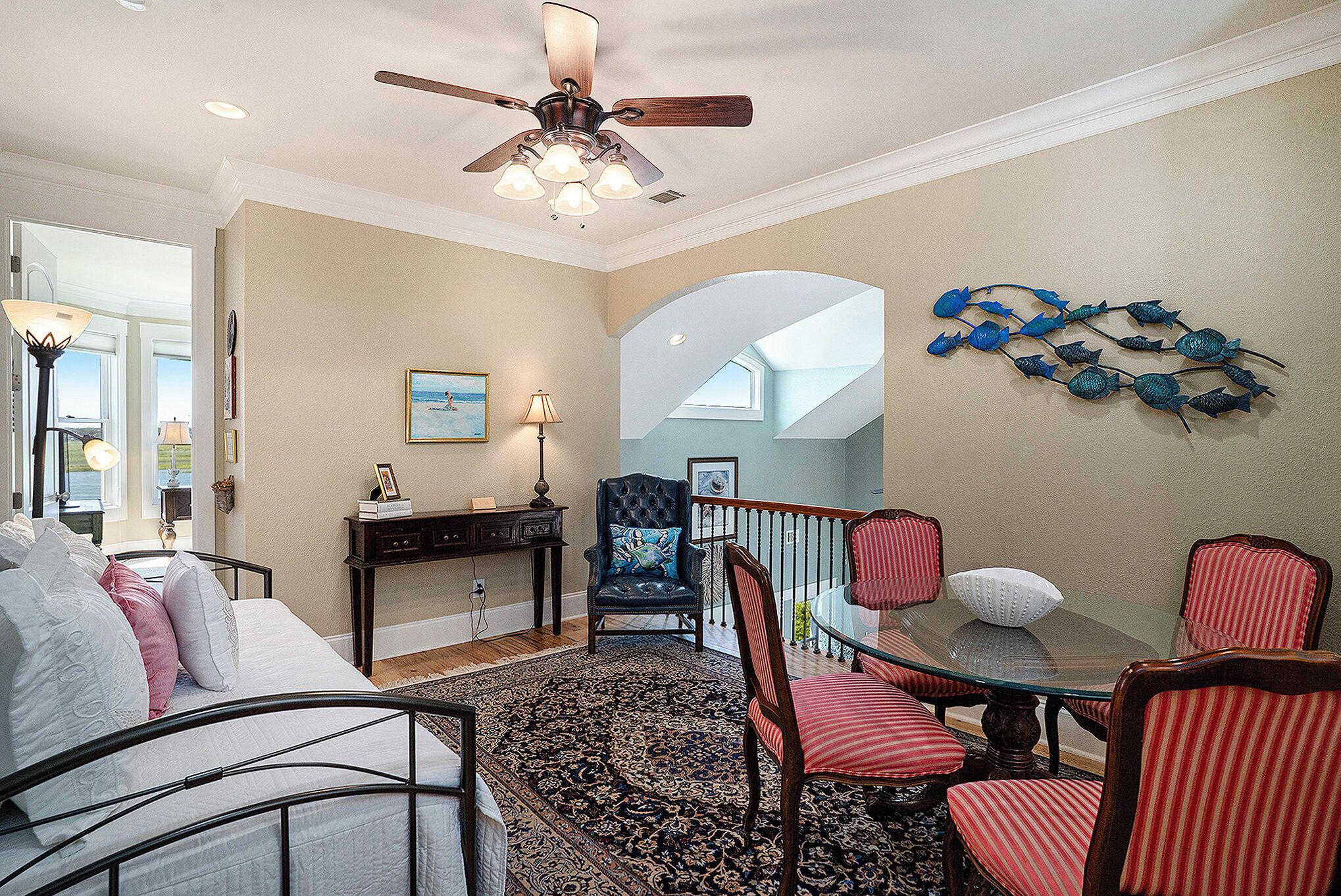 A bedroom with a bed, a nightstand, a lamp, and a ceiling fan.