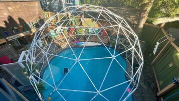 A swimming pool surrounded by a geodesic dome structure.