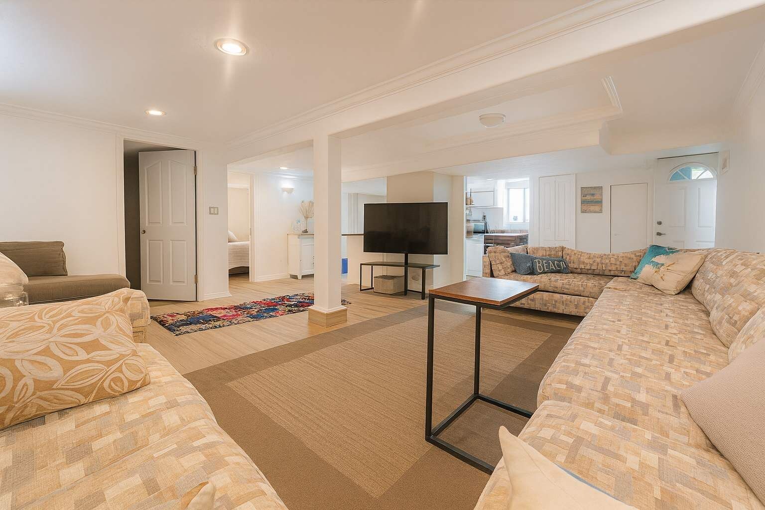 A spacious living room with a sofa set, a coffee table, and a TV.