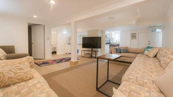 A spacious living room with a sofa set, a coffee table, and a TV.