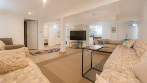 A spacious living room with a sofa set, a coffee table, and a TV. - Poolside Hideaway • Heated Pool All Year • Ideal for Groups (Sleeps 6+) (Victoria)