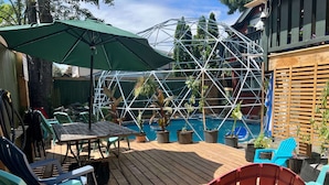 A wooden deck with a pool, potted plants, and outdoor furniture. - Poolside Hideaway • Heated Pool All Year • Ideal for Groups (Sleeps 6+) (Victoria)