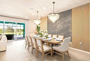 Dining area with pool deck views through the sliders - dinner steps from a swim. - New Resort, Private Pool & Spa, Outdoor Theater, Game Room, Minutes to Disney World (Clermont)