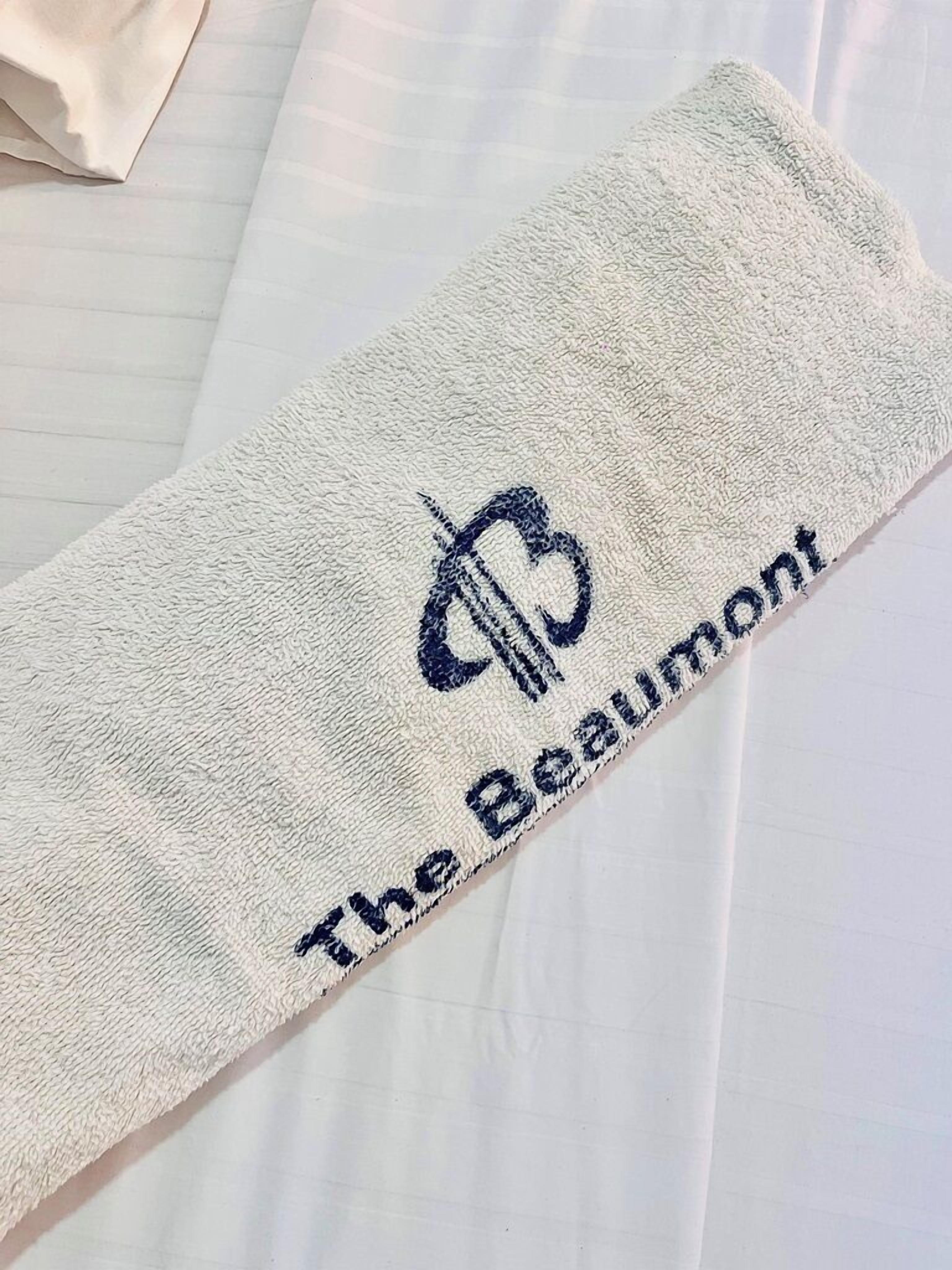 A towel with embroidered text "The Beaumont" on a white fabric.