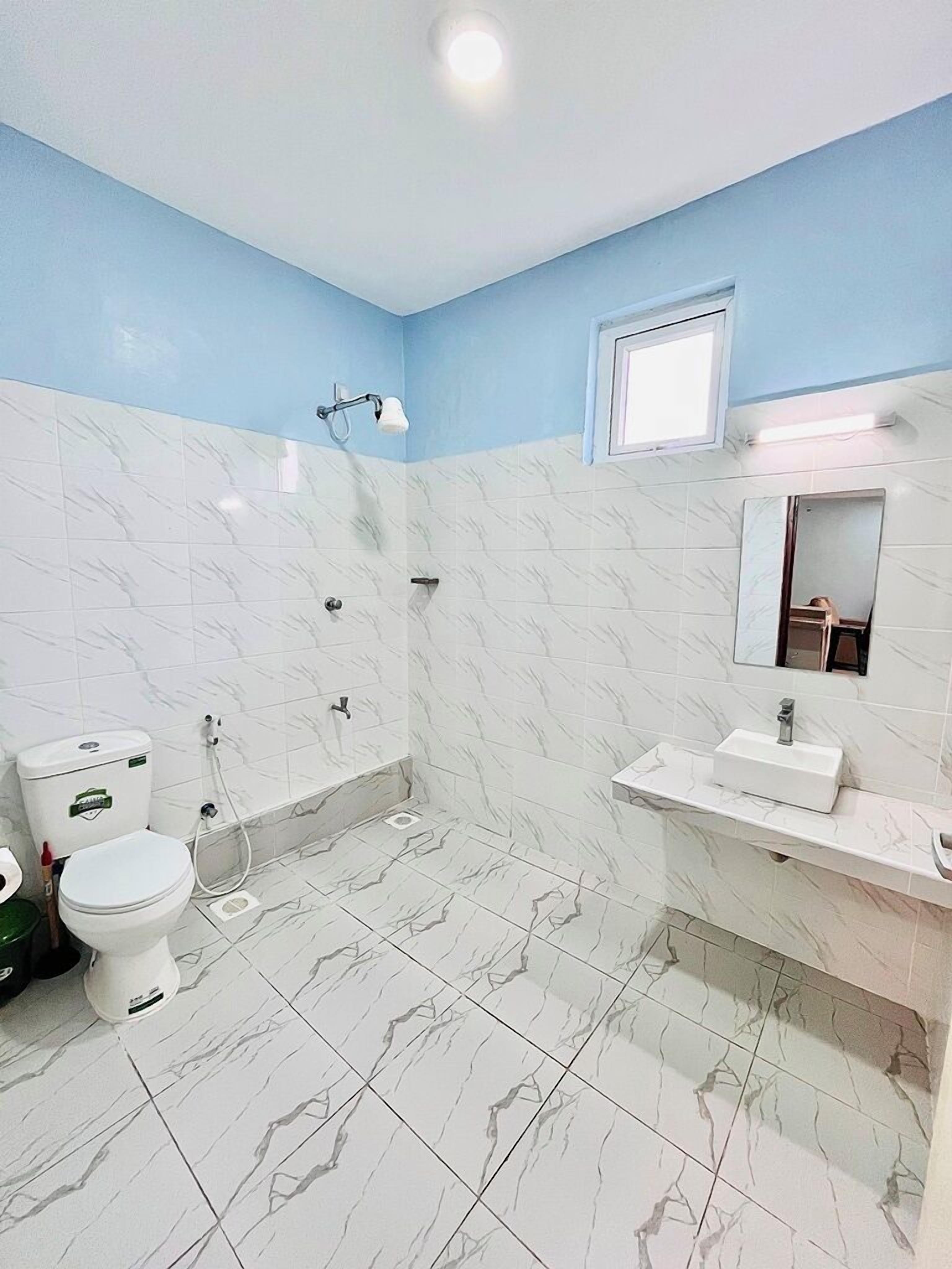 A bathroom with a toilet, sink, and shower.