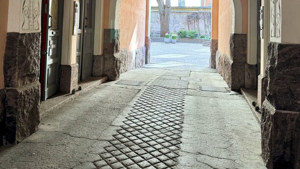 An arched corridor with patterned flooring, stone walls, and a view of the outside. - Melrose Place for 5 people (Helsinki)