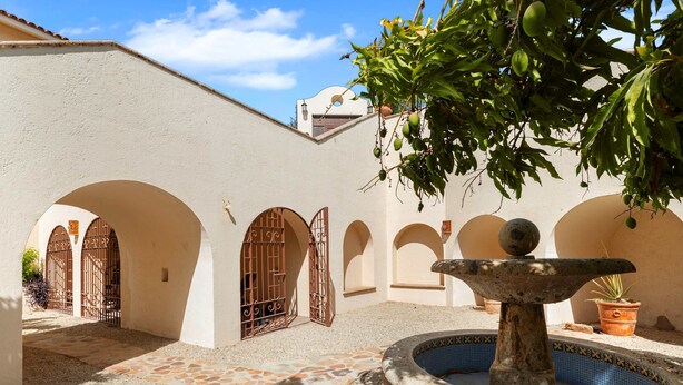 A courtyard with a fountain, stone flooring, and arched doorways. - Cabo Villa for 20 w Ocean Views Pool Hot tub (San José del Cabo)