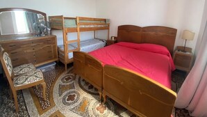 A bedroom with a bunk bed, a wooden dresser with drawers, a mirror, and a bedside lamp. - Green Wave apartment (Camogli)