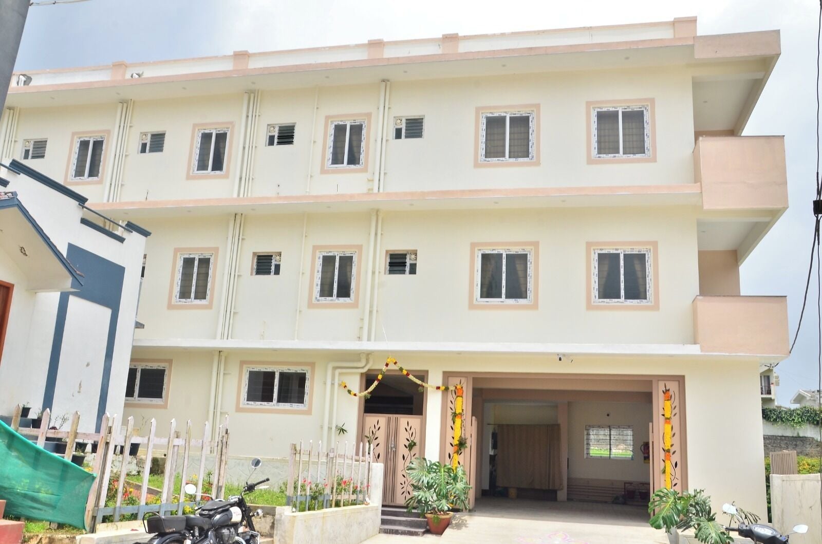 A multi-story residential building with a flat facade, multiple windows, and a gated entrance.
