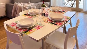 A dining area with a table set for four, a bottle of wine, and a floral table runner. - Romantic Loft in the historic center of Lucca, ideal for visiting the city on foot (Lucca)
