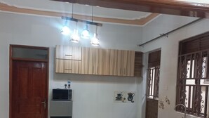 Una cocina con armarios de madera, un refrigerador, un lavamanos y un ventanal con barandales decorativos.