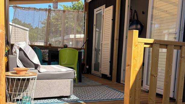 A wooden deck with a sofa, chairs, and a table. - Mobilhome cap ferret (Lège-Cap-Ferret)