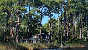 A house surrounded by tall pine trees near a body of water. - Point & Paddle
Waterfront Retreat @Alligator Point (Alligator Point)