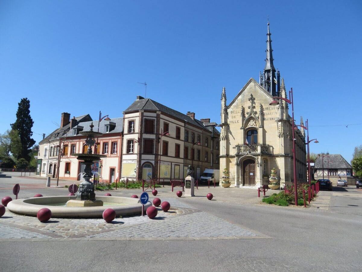 Un edificio storico con una torre imponente e una fontana al centro.