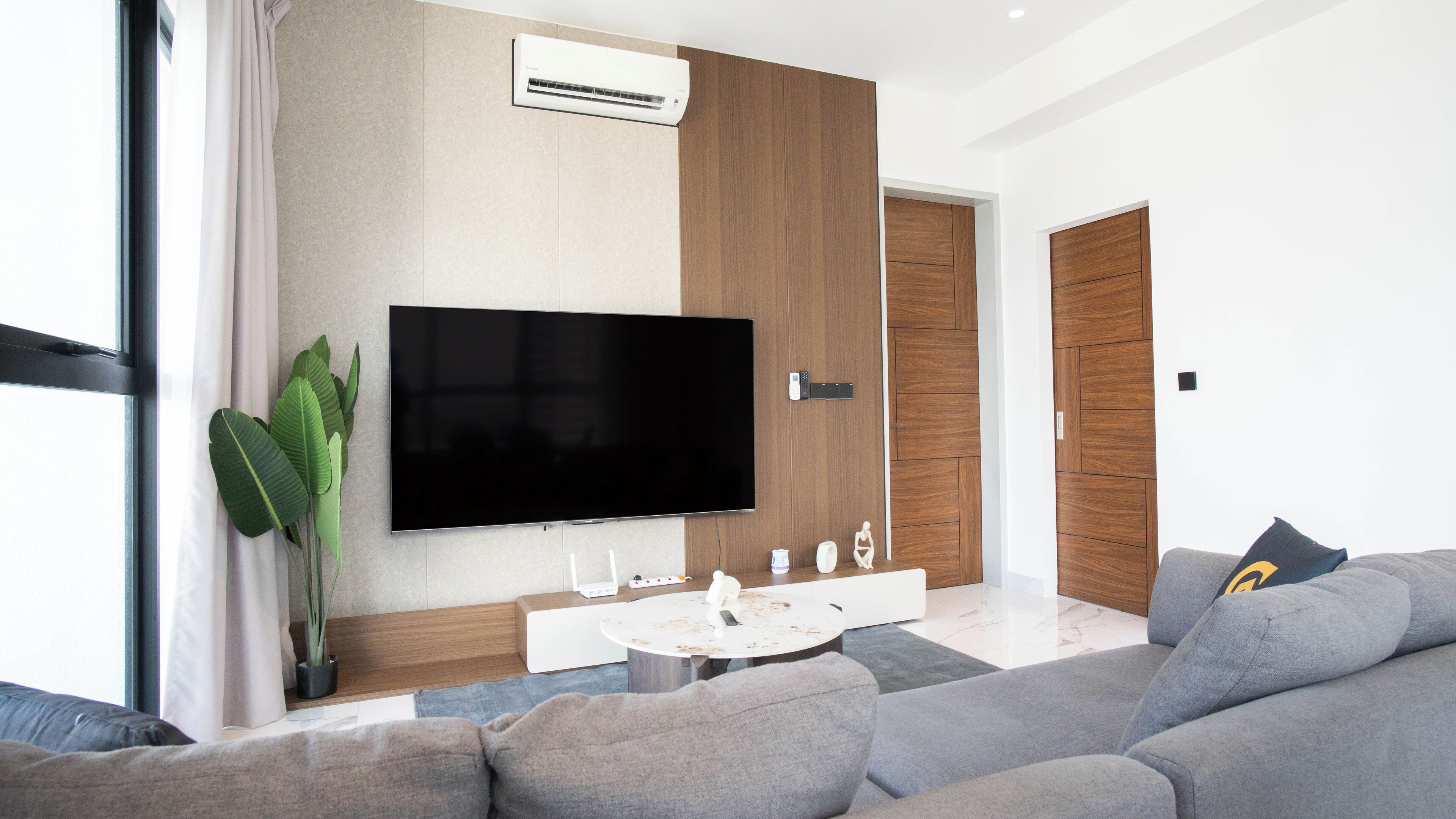 Una sala de estar moderna con una televisión de pantalla plana, una mesa de centro y un sofá.