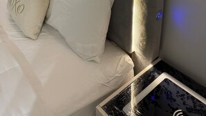 Una cama con cabecera que tiene luz integrada.