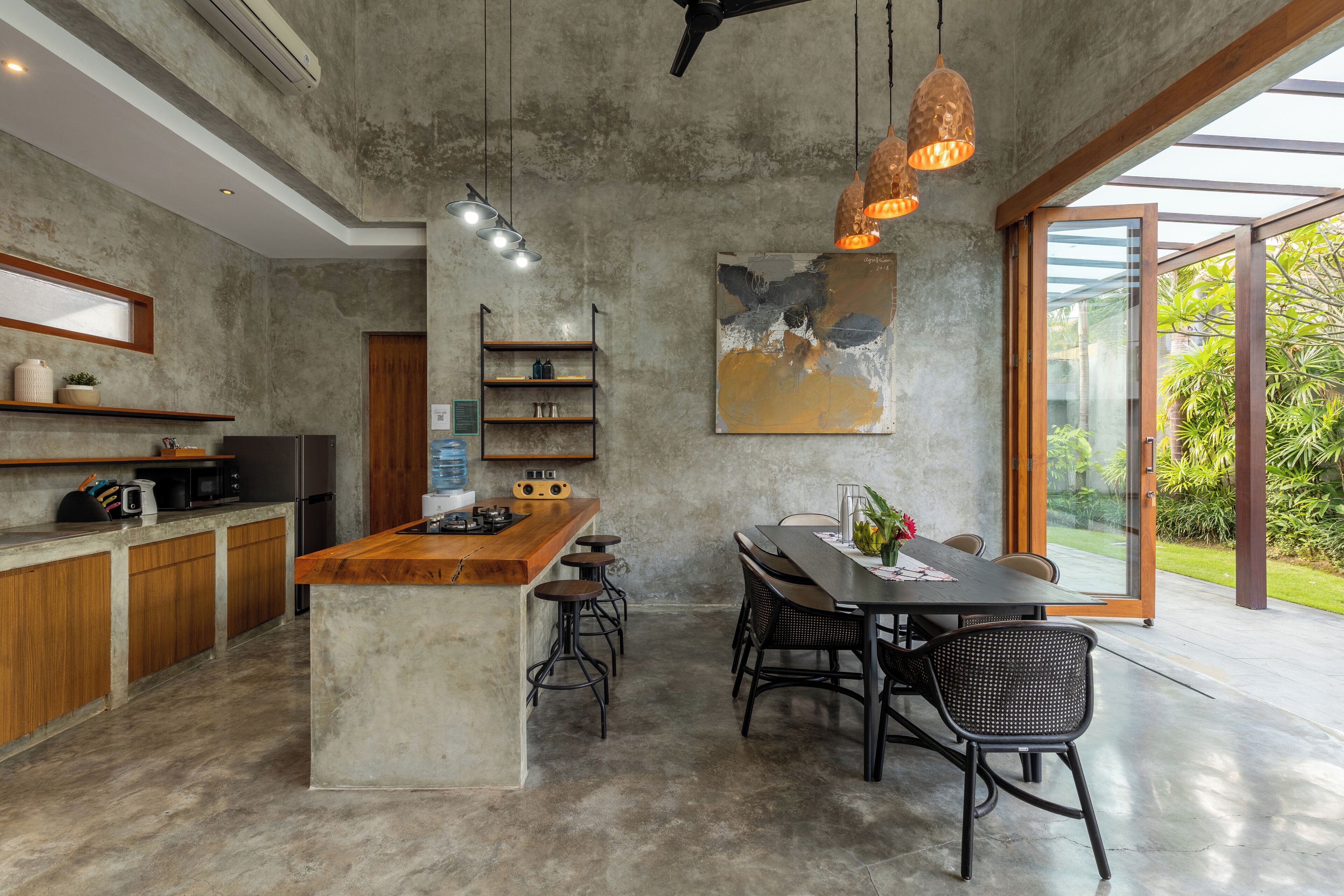 A modern kitchen with a central island, bar stools, and pendant lighting.