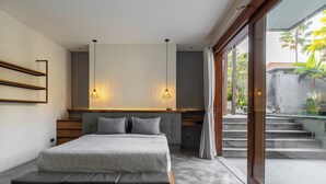 Ein modernes Schlafzimmer mit einem großen Bett, einem Holzkopfende und Pendelleuchten.