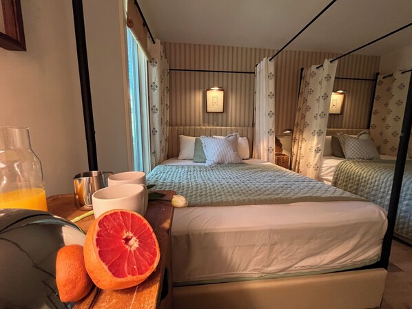 A hotel room with a bed, bedside table, and a window with curtains.