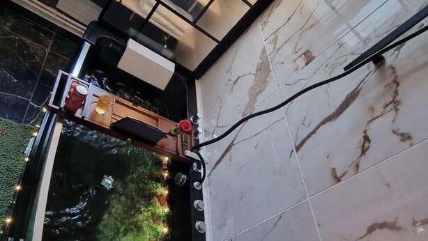 A modern bathroom with a marble floor, a black sink, and a mirror. There are candles on the floor and a towel rack on the wall. - Beautiful apartment in Tours center, panoramic view of the city. (Tours)