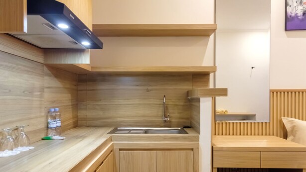 Een moderne keuken met houten kastjes, een roestvrijstalen spoelbak en een inbouw afzuigkap.