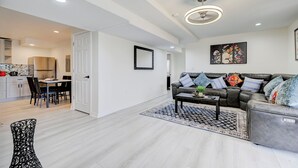 Un salon moderne comprenant un canapé, une table basse et un coin repas avec des chaises et une table.
