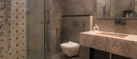 A modern bathroom with a glass-enclosed shower, a toilet, and a vanity with a mirror.