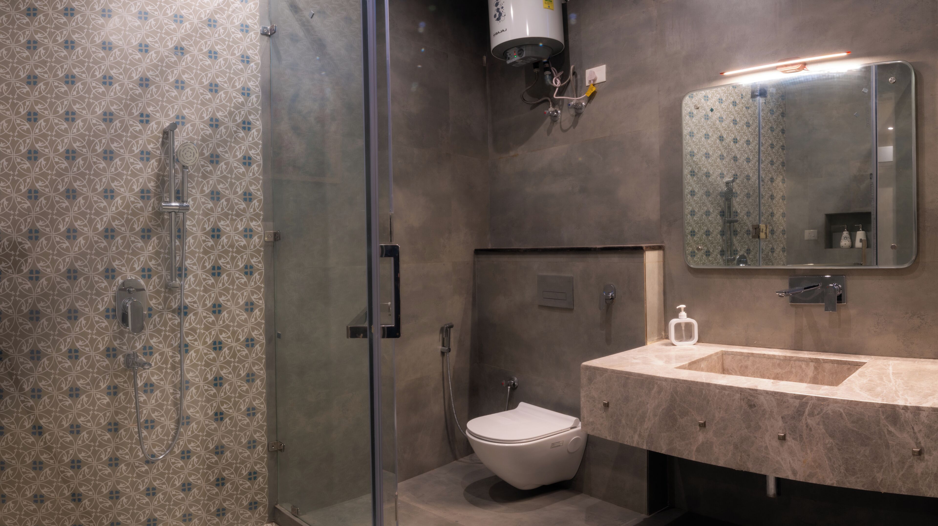 Un baño moderno con cabina de ducha de vidrio, inodoro y lavabo con espejo.