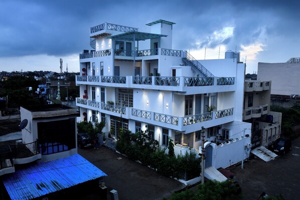 A multi-story building with balconies and a flat roof.