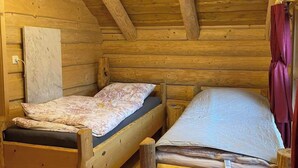 A cabin with two wooden bunk beds, a wooden ceiling with exposed beams, and a hanging light fixture. - Vacation home by the lake - Trausnitz. Nature, peace, relaxation (Trausnitz)