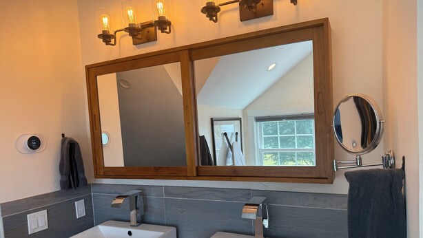 A bathroom with two white sinks, a large mirror, and a wooden vanity. - “Unwind, recharge, and experience the magic of Maine's Working Waterfront (St. George)