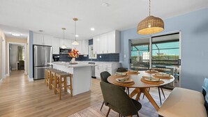A modern kitchen with white cabinets, stainless steel appliances, and a central island. - One Last Summer Family Escape Pool• Arcade• Games (Bradenton)