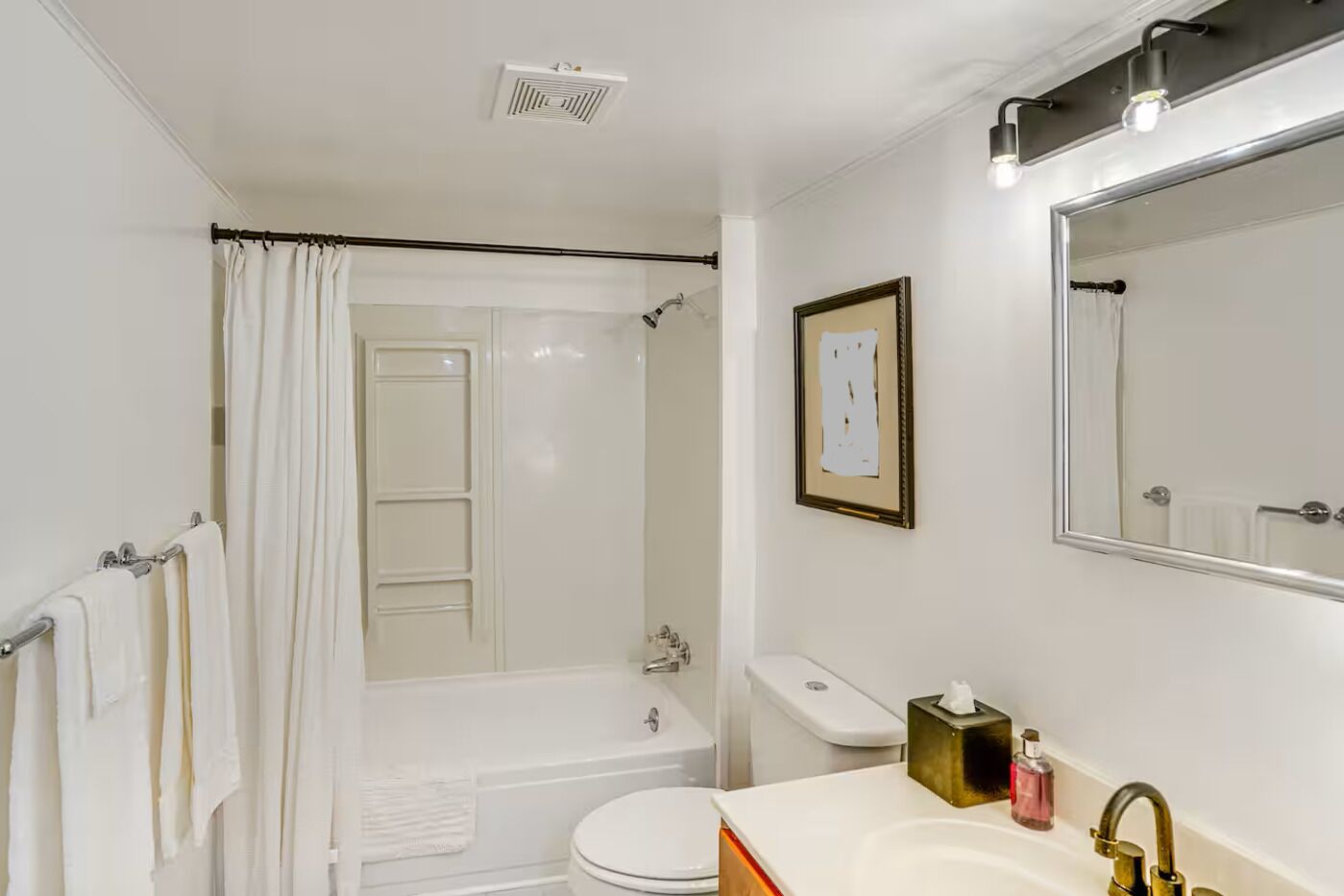A bathroom with a bathtub, toilet, sink, and a shower curtain.