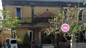 A two-story building with a tiled roof, a gated entrance, and a paved driveway. - Hotel Taman Rai  (Tabanan)