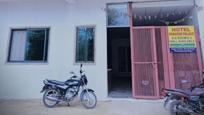 A two-story building with a balcony on the upper floor. There is a sign for a hotel named "Narayan Palace" with available rooms and a hall. - Hotel Narayan Palace (Danta Ramgarh)