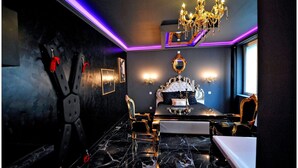 Une chambre à coucher luxueuse, dotée d’un grand lit, d’un lustre et d’un sol en marbre.