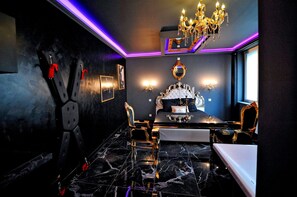 Ein luxuriöses Schlafzimmer mit einem großen Bett, einer Kristallleuchtre und einem Marmorboden.