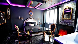 Une chambre à coucher luxueuse, dotée d’un grand lit, de meubles richement décorés et d’une cheminée.