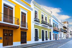 A row of colorful colonial-style buildings with balconies and wooden doors.