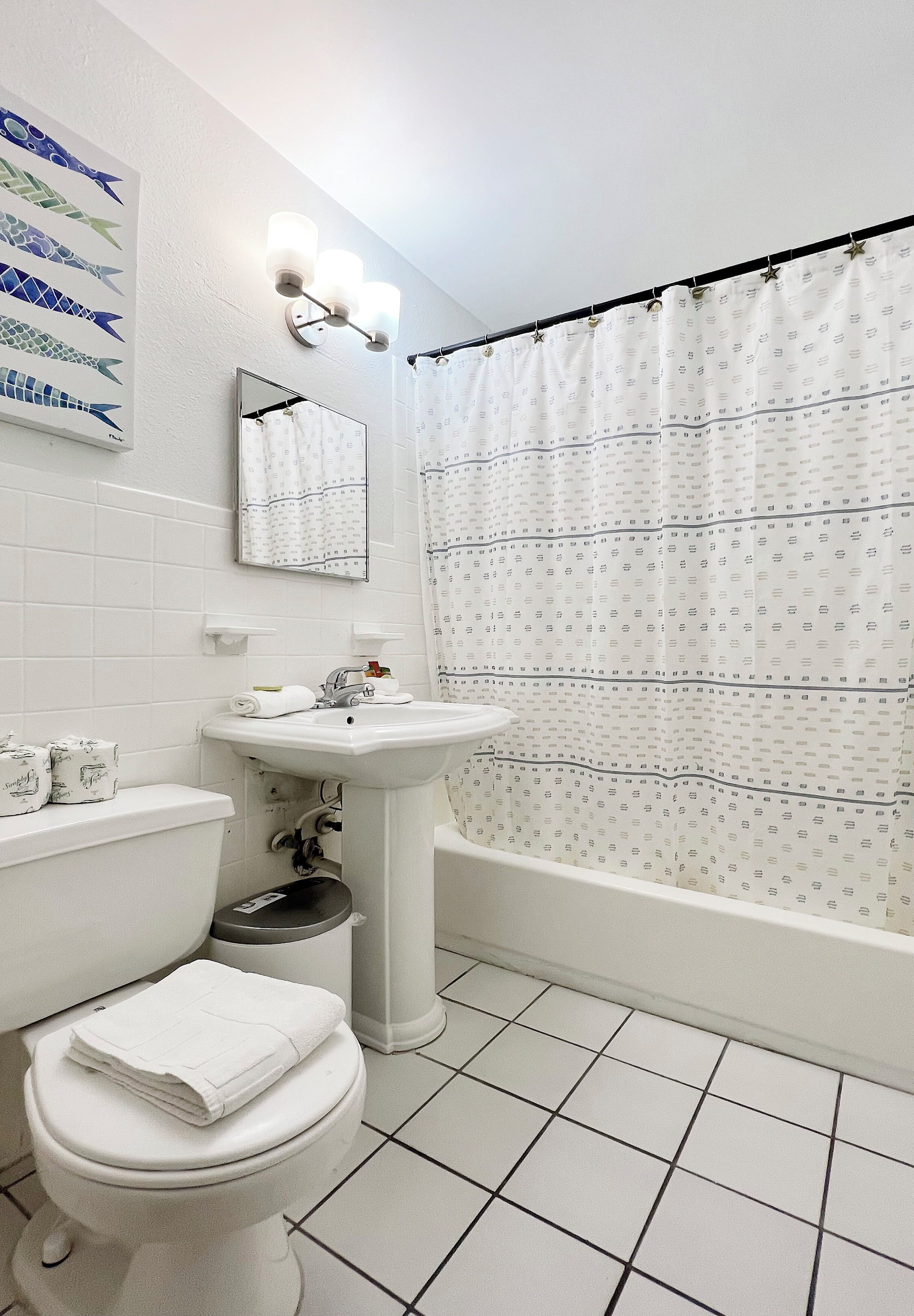 A bathroom with a toilet, sink, and bathtub.