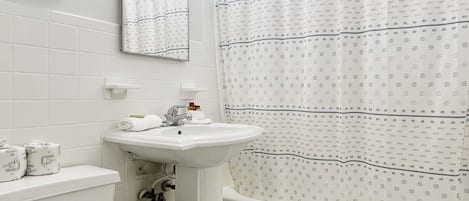 A bathroom with a toilet, sink, and bathtub.
