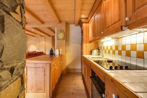 Een keuken met houten kastjes, een betegelde spatwand en een centraal eiland.
