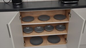 Un armario de cocina con varios estantes que sostienen platos.