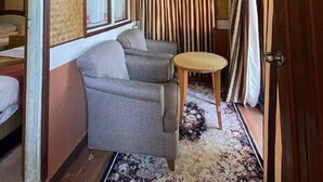 A narrow hallway with a star-shaped ceiling light, striped curtains, a patterned rug, and a small round table. - CoralView Perhentian Besar Resort (Pulau Perhentian Besar)