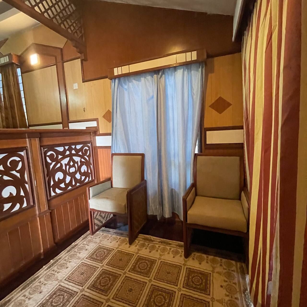 A traditional room with a patterned floor, wooden furniture, and a curtain.