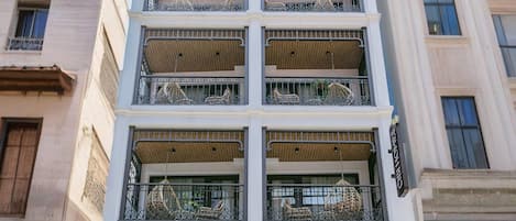 Un edificio de varios pisos con balcones, un escaparate con la inscripción 'CIBI HOMES Hanoi Central Living Space' y un puesto de café llamado 'PARO Coffee stand' con un letrero que dice 'Panadería, Té y Café'.