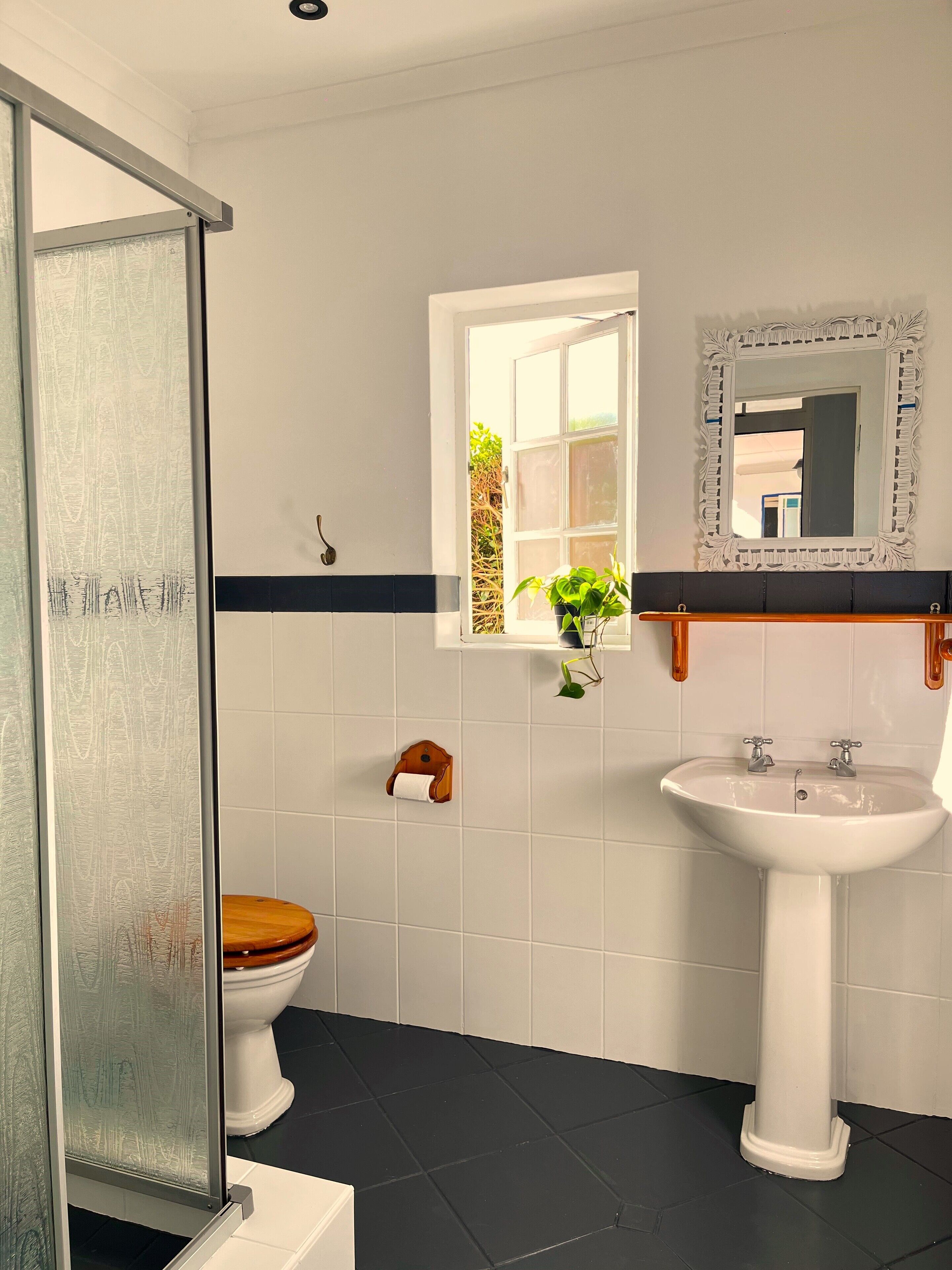 A bathroom with a white sink, a toilet, and a shower.